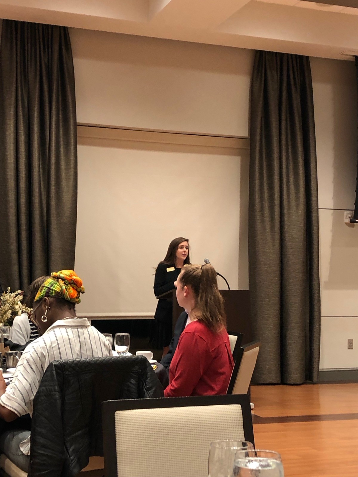 Ceci presenting at the Etiquette Dinner she created, speaking to a room of students at a formal dining event