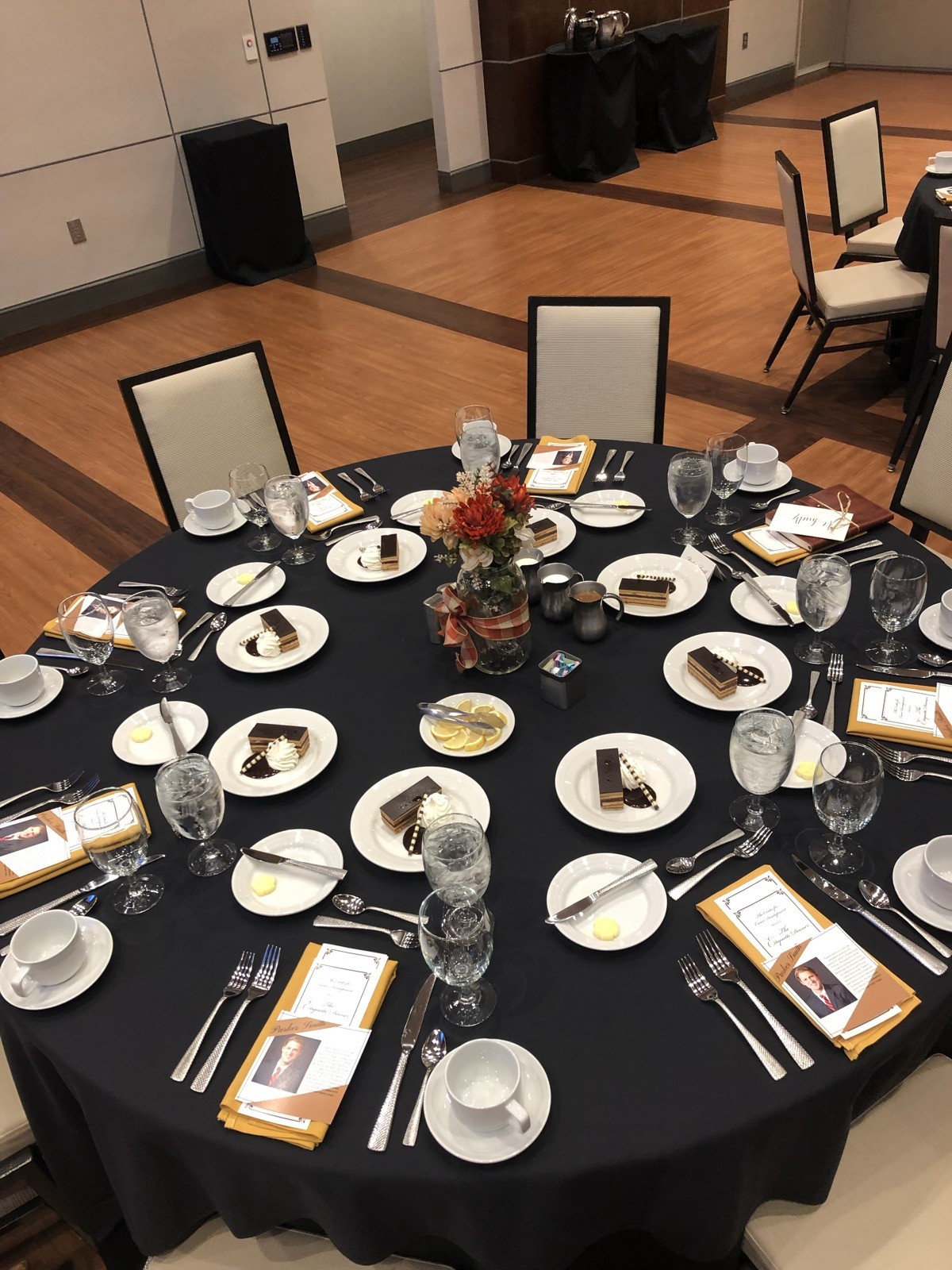 Beautifully set formal dining table at the Etiquette Dinner — menus, place settings, flowers, and wine glasses