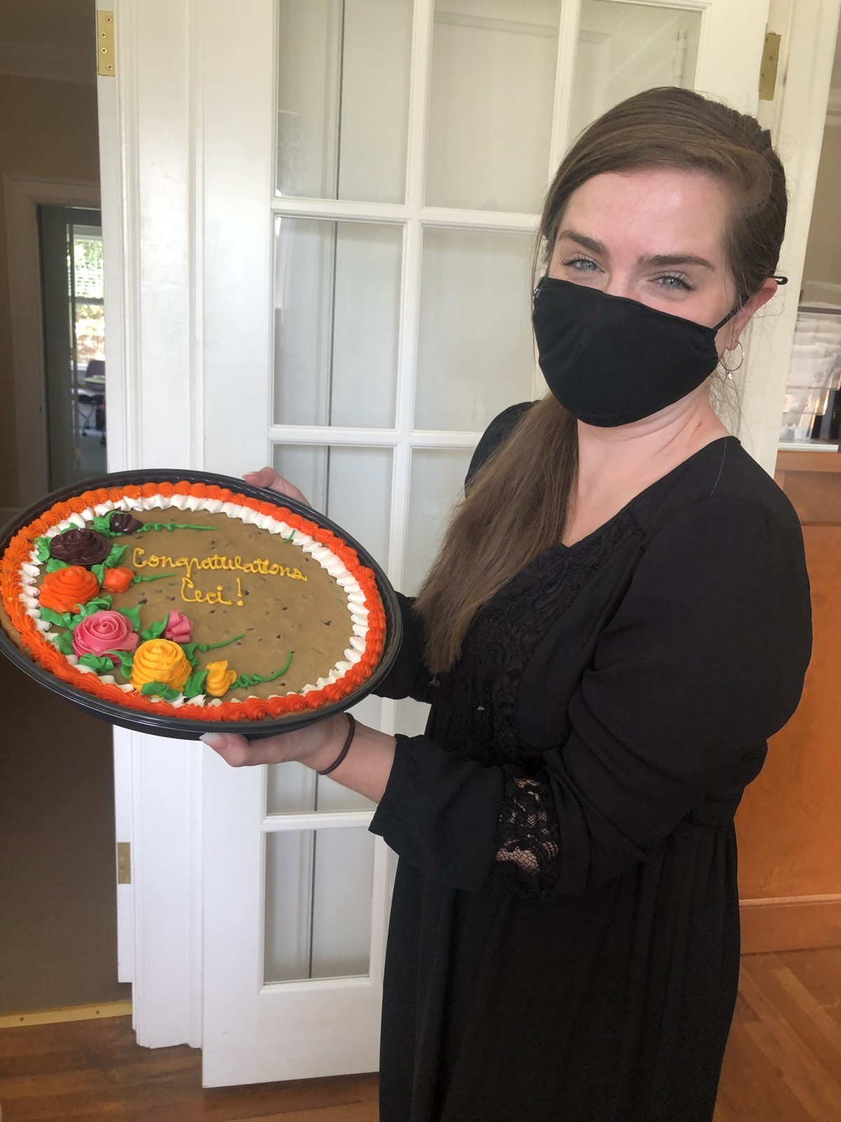 Ceci holding her promotion celebration cookie cake